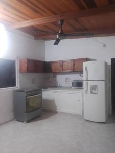 a kitchen with white appliances and wooden cabinets at VIVIENDA TURISTICA GAIRA in Rodadero