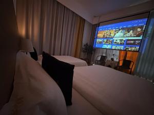 um quarto de hotel com duas camas e um grande ecrã em 林涧小栈Linger house em Yangshuo