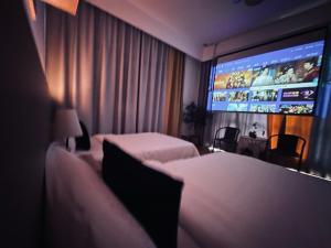 um quarto de hotel com duas camas e uma televisão de ecrã plano em 林涧小栈Linger house em Yangshuo