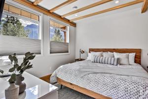 Un dormitorio con una cama y dos ventanas. en Ravens Crest Lodge - Stunning Views Perfectly Located on Main Street, en Canmore 36 fotos más