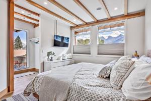 Un dormitorio con una cama grande y una ventana en Ravens Crest Lodge - Stunning Views Perfectly Located on Main Street, en Canmore