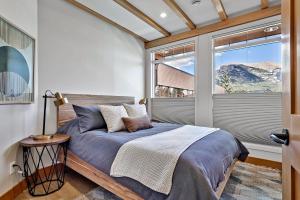 a bedroom with a bed and a large window at Ravens Crest Lodge - Stunning Views Perfectly Located on Main Street in Canmore