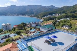 a pool with umbrellas and a view of the water at Melodia Pension in Geoje