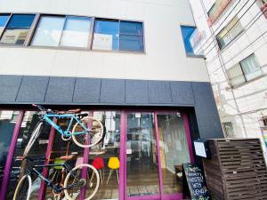 una bicicletta appesa alla parte anteriore di un edificio di KandO Hostel Ueno a Tokyo