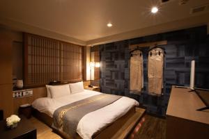 1 dormitorio con cama y pared de piedra en HOTEL KSEA (Adult Only), en Matsudo