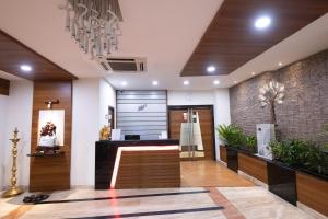 a lobby with a reception area with a chandelier at Hotel High Point in Tiruchirappalli