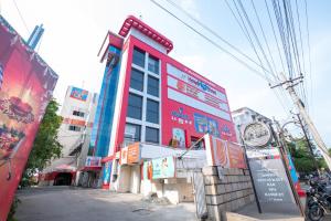 um edifício vermelho com placas na lateral em Hotel High Point em Tiruchchirappalli