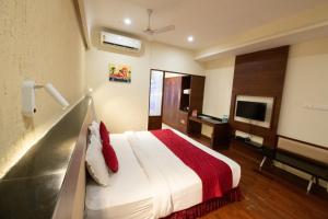 a hotel room with a bed and a television at Hotel High Point in Tiruchirappalli