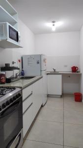 uma cozinha branca com um fogão e um frigorífico em Cozy apartment in Palermo II em Buenos Aires