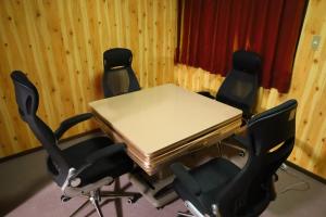 a table with four chairs and a laptop on it at Luna House in Nakano