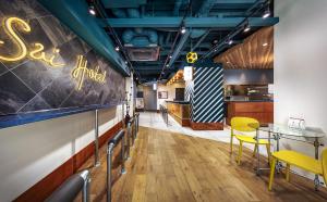 a dining room with a table and yellow chairs at Sai Hotel in Shizuoka