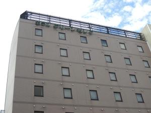 a building with a balcony on top of it at Hotel Green Selec in Sendai