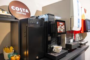 a coffee shop with a coffee machine on a counter at Sai Hotel in Shizuoka