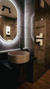 baño con lavabo redondo y espejo en Atrium Apartments Aachen, en Aachen