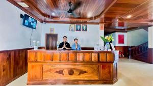 zwei Personen stehen an einer Bar in einem Zimmer in der Unterkunft Harmony Indochine d'Angkor in Siem Reap