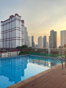 a swimming pool with a city skyline in the background at Top High Airport Link Hotel, Bangkok in Bangkok