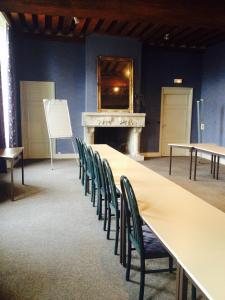 een lange tafel en stoelen in een kamer met een open haard bij Jackotel in Orléans