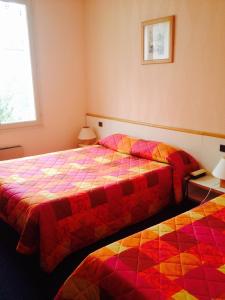 two beds sitting next to each other in a room at Jackotel in Orléans