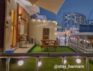 a balcony with a table and an umbrella at Stay Hannam in Seoul