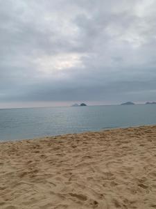 a sandy beach with a view of the ocean at Chalé Praia de Boiçucanga in Boicucanga