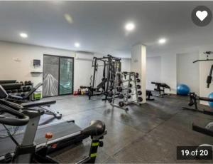 a gym with treadmills and machines in a room at Elegant Condo in an Upscale Building in Cabo San Lucas