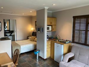 een kleine kamer met een keuken en een slaapkamer bij Haus Barbara Guest House in Bredasdorp
