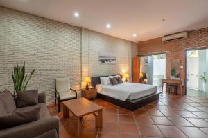 ein Schlafzimmer mit einem Bett und einer Ziegelwand in der Unterkunft Mekong Long Thanh Resort & Reststop in Ấp Thanh Nguyên