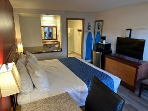 um quarto de hotel com uma cama e uma televisão de ecrã plano em Econo Lodge Edmonds North Seattle em Edmonds