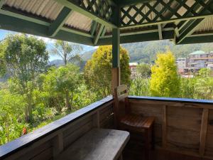 a bench on a porch with a view of the mountains at Saint Joseph Inn in Sagada