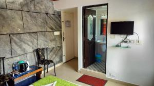 a room with a bathroom with a tv and a mirror at Achus Holidays in Munnar