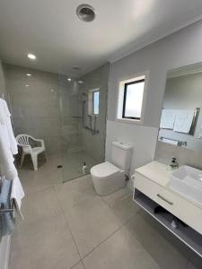 a bathroom with a toilet and a sink and a shower at Taipa Views Bed & Breakfast in Kaitaia