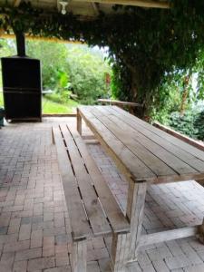 - une table de pique-nique en bois assise sur une terrasse en briques dans l'établissement Cabaña Bella Vista, à Pereira