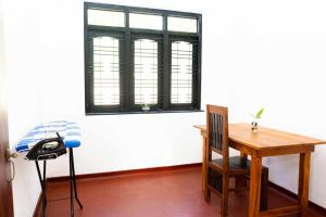 una mesa y una silla en una habitación con ventana en Binu Villa, en Weligama