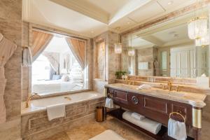 a bathroom with a tub and a large mirror at The Castle Hotel, a Luxury Collection Hotel, Dalian in Dalian