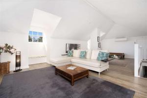 a living room with a white couch and a coffee table at Myrtle Tree Lodge Leaves, Kangaroo Valley in Kangaroo Valley