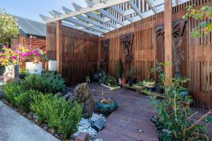 a garden with a wooden deck with potted plants at Myrtle Tree Lodge Leaves, Kangaroo Valley in Kangaroo Valley