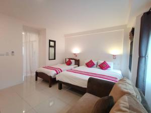 um quarto de hotel com duas camas e um sofá em Sasima House em Chiang Mai