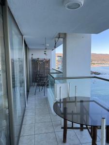 una mesa de cristal en una habitación con vistas al agua en Departamento Esmeralda Pingueral, en Dichato