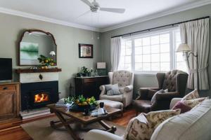 a living room with a couch and chairs and a fireplace at Lemon Tree Cottage, Kangaroo Valley in Kangaroo Valley