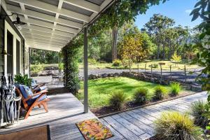 a wooden porch with a view of a garden at Lemon Tree Cottage, Kangaroo Valley in Kangaroo Valley