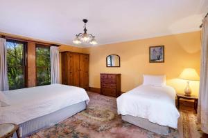 a bedroom with two beds and a window at Kayenta, Kangaroo Valley in Kangaroo Valley