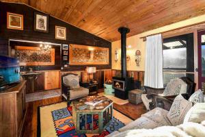 sala de estar con paredes revestidas de madera y chimenea en Kayenta, Kangaroo Valley, en Valle Kangaroo
