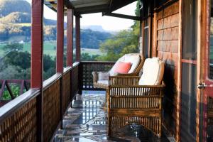 a porch with wicker chairs and a view of the mountains at Kayenta, Kangaroo Valley in Kangaroo Valley