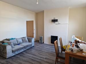 a living room with a couch and a table at Cozy Bedroom in Spacious House Manchester in Rochdale