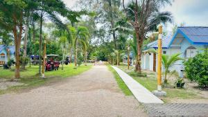 a dirt road in a park with palm trees at PAN Beachfront Resort Krabi in Klong Muang Beach