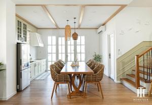 a dining room with a wooden table and chairs at Villa 3PN Novaworld Phan Thiết in Phan Thiet