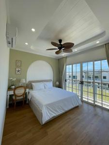 1 dormitorio con 1 cama y ventilador de techo en Villa 3PN Novaworld Phan Thiết, en Phan Thiet