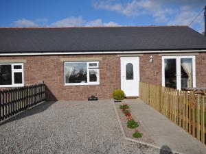 a brick house with a fence and a driveway at 2 Bed in Blakeney 54766 in Awre