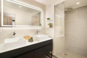 a bathroom with two sinks and a shower at Tetavake Luxury Suite in Punaauia