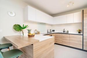 a kitchen with white cabinets and a wooden counter top at Tetavake Luxury Suite in Punaauia
